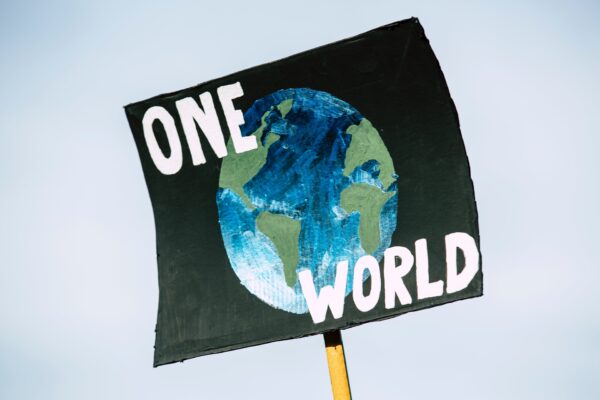Painted poster that says "one world"
