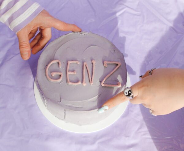 Person Wearing a Yin Yang Ring touching a cake labeled Gen Z