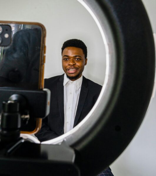 Man in suit recording a video with ring light